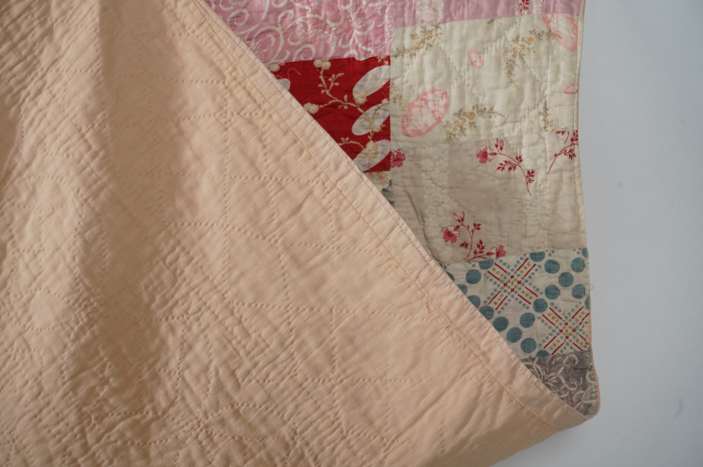 A late 19th early 20th century English cotton ‘scrap bag’ quilt., Made from a large variety of fashionable printed floral, striped and checked cottons of the day, cut into different sized rectangles and squares. Backed w
